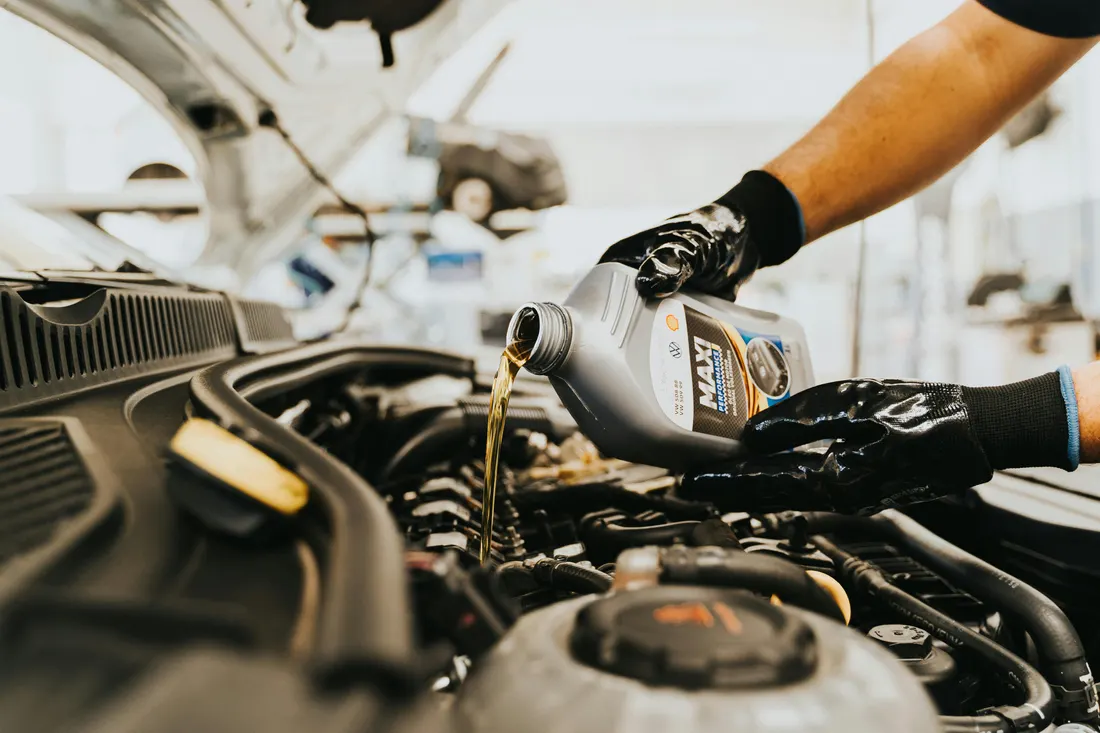 Mobile oil change — fresh engine oil being poured during a service